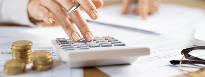 Calculator next to coins on desk