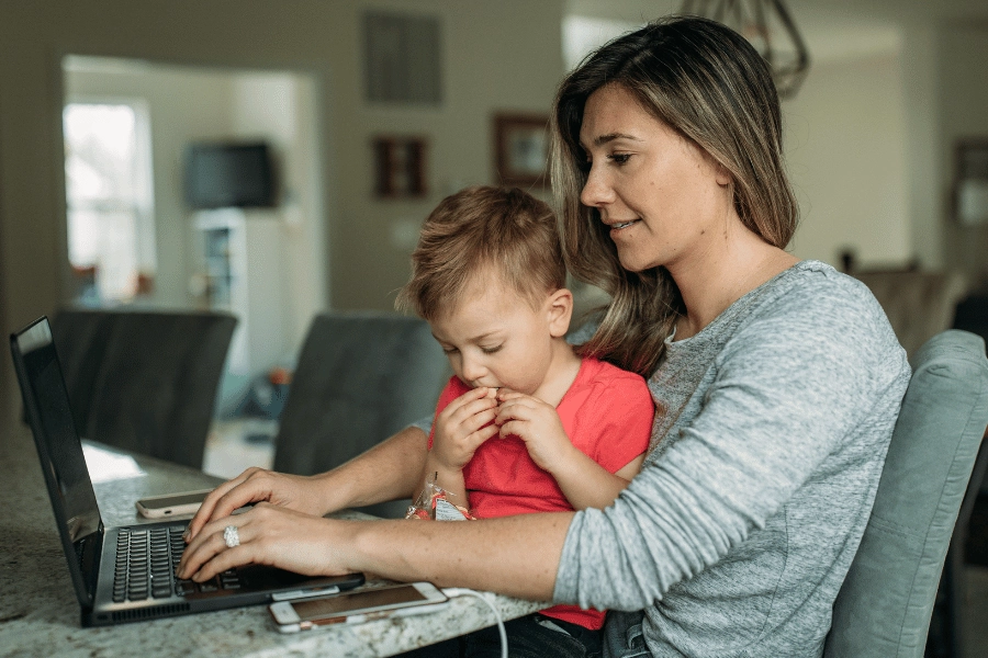 Woman working from home with a child on her lap