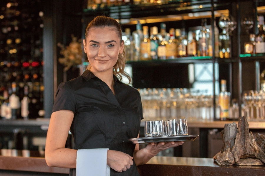 Waitress holding a tray on glasses