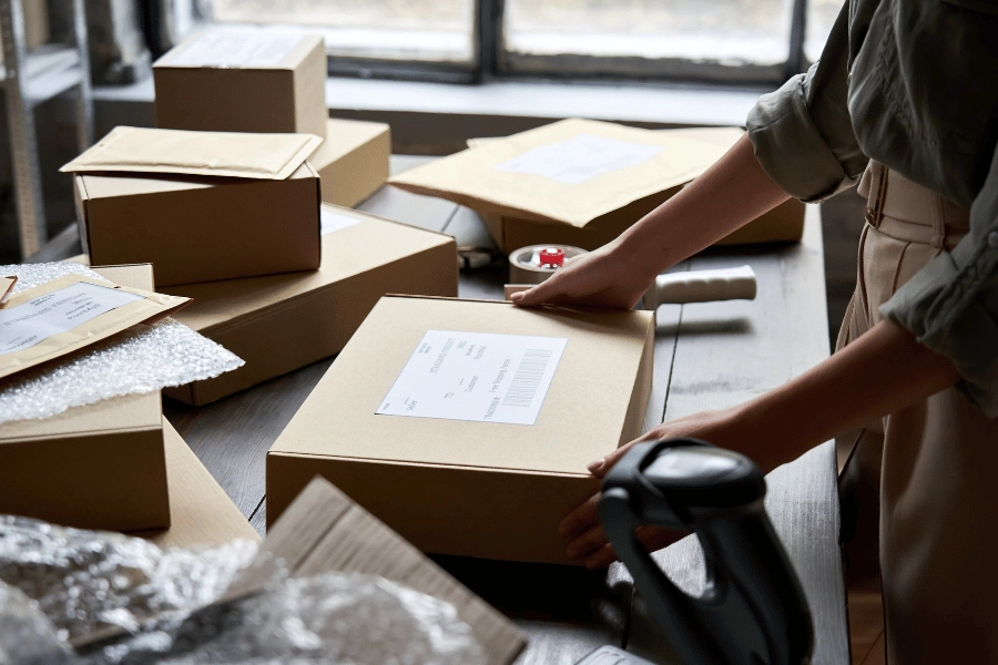 Woman packing orders in boxes and envelopes