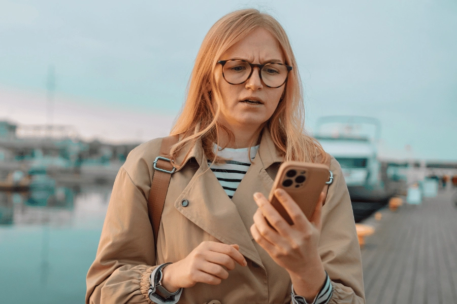 Woman looking at phone screen with a confused expression