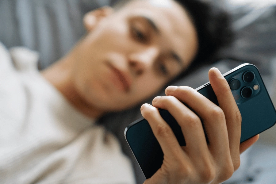 Man laying down looking at mobile phone